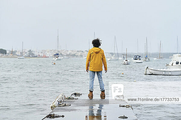 Man standing on jetty in front of sea