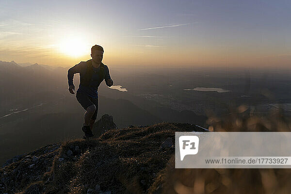 Silhouette-Wanderer läuft bei Sonnenuntergang auf dem Berg