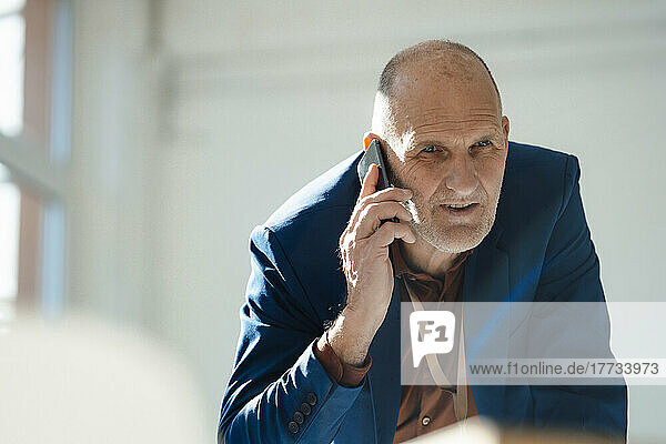 Businessman talking on mobile phone in office
