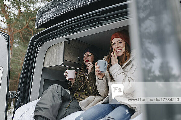 Lächelnde Frauen  die gemeinsam im Wohnmobil Kaffee genießen