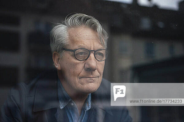 Thoughtful senior businessman looking out of window