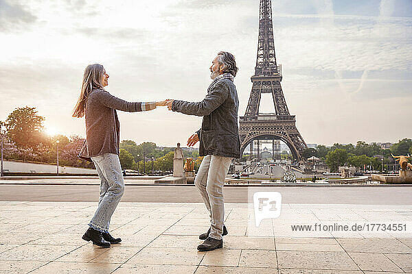 Happy mature man with woman dancing in front of Eiffel Tower  Paris  France