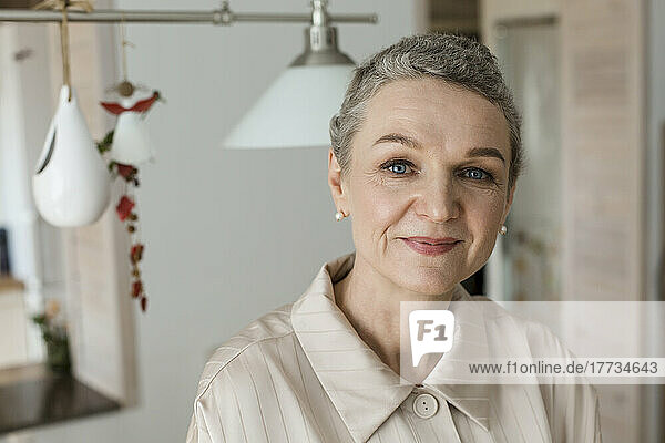 Portrait of confident mature woman with short grey hair at home