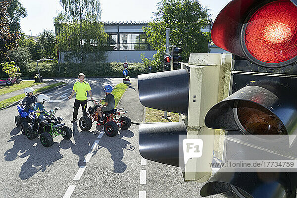 Instructor giving training to children on quadbikes at traffic education training