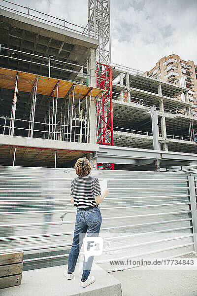 Architect looking at incomplete building under construction