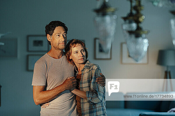 Woman with man standing in living room at home