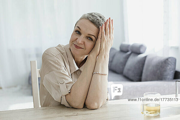 Portrait of mature woman sitting at table at home