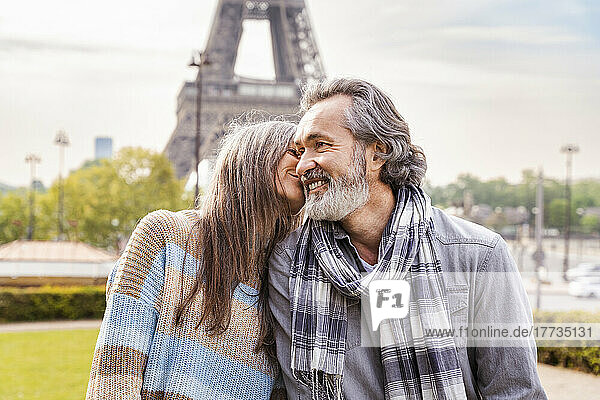 Mature woman kissing boyfriend in front of Eiffel tower  Paris  France