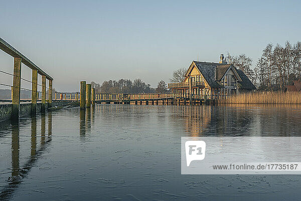 Germany  Schleswig-Holstein  Hemmelsdorf  Pier on shore of Hemmelsdorfer See with house in background