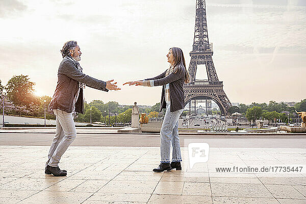 Smiling mature couple dancing in front of Eiffel Tower  Paris  France