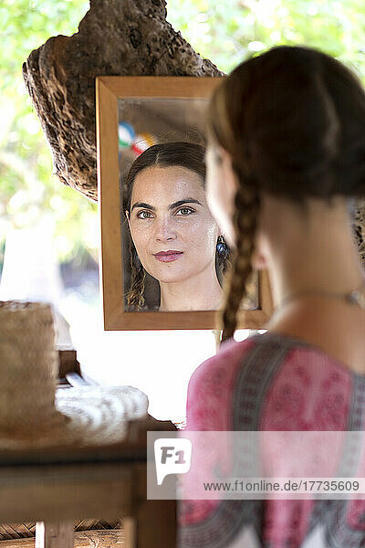 Selbstbewusste Frau  die sich selbst im Spiegel betrachtet