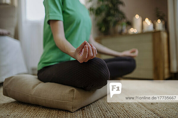 Woman practicing lotus position at home