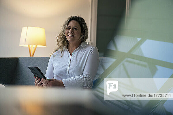 Smiling businesswoman with tablet PC in office