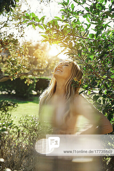 Happy mature woman enjoying sunny day at park