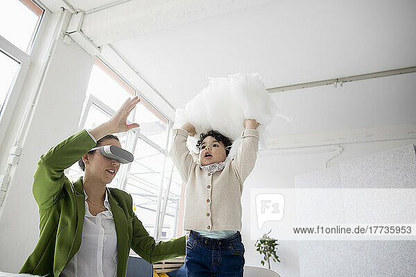 Mother and daughter exploring the metaverse in the cloud using virtual reality simulator
