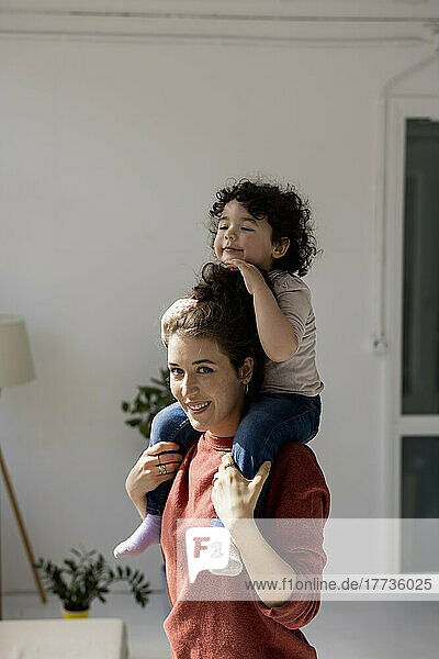 Mother carrying daughter on shoulders