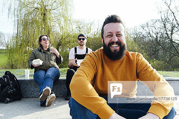 Friends laughing together sitting in park
