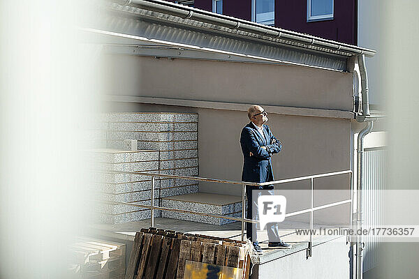 Businessman standing with arms crossed at construction site