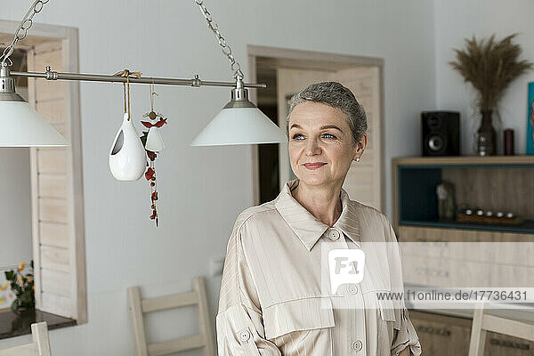 Confident mature woman with short grey hair at home