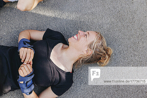 Happy woman lying on sports ramp