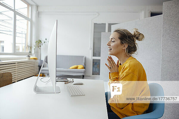 Geschäftsfrau bei Videoanruf über Desktop-PC zu Hause