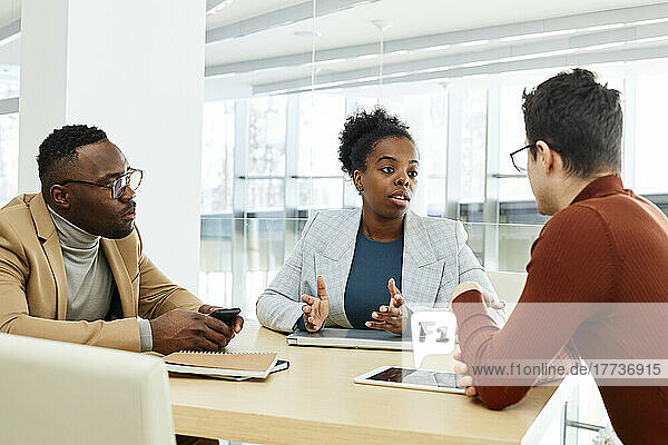 Young businesswoman discussing strategy with colleagues in office