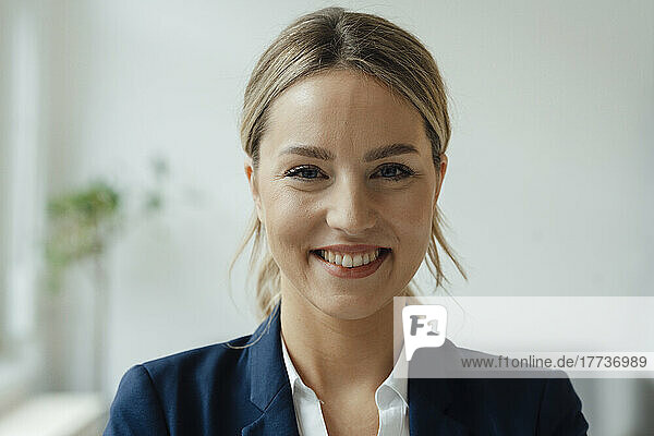 Smiling beautiful blond businesswoman in office