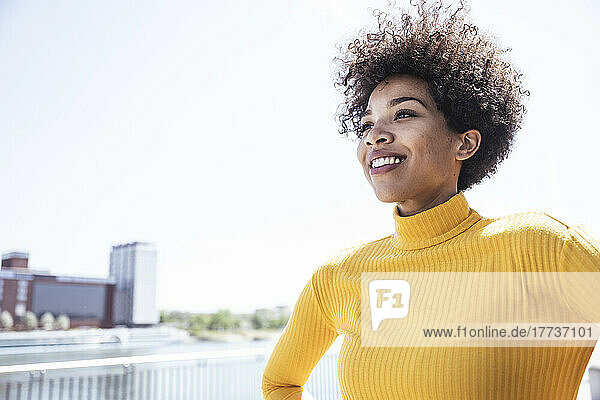 Smiling woman with Afro hairstyle on sunny day