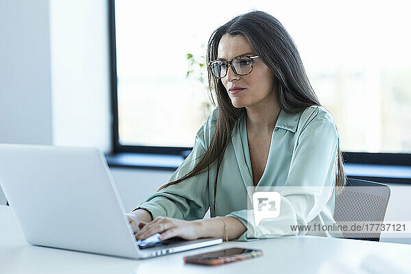 Geschäftsfrau arbeitet konzentriert am Laptop im Büro