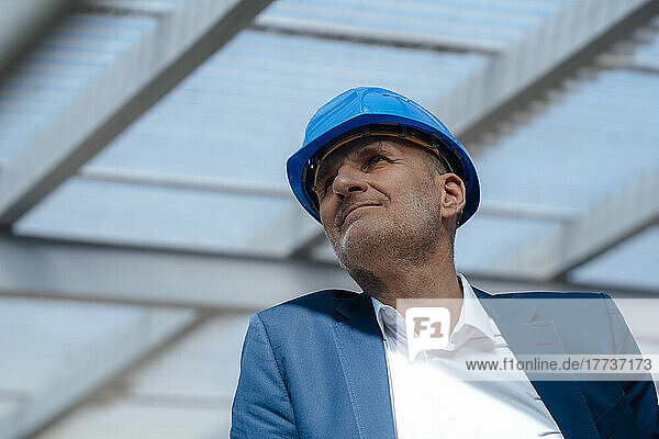 Senior businessman wearing hardhat at construction site