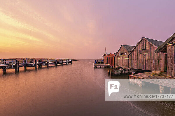 Germany  Mecklenburg-Western Pomerania  Zingst  Pier and row of coastal boathouses at moody dusk