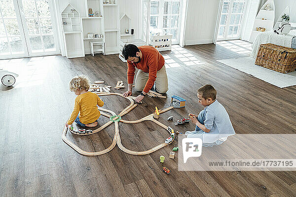 Vater und Sohn spielen zu Hause mit der Spielzeugeisenbahn