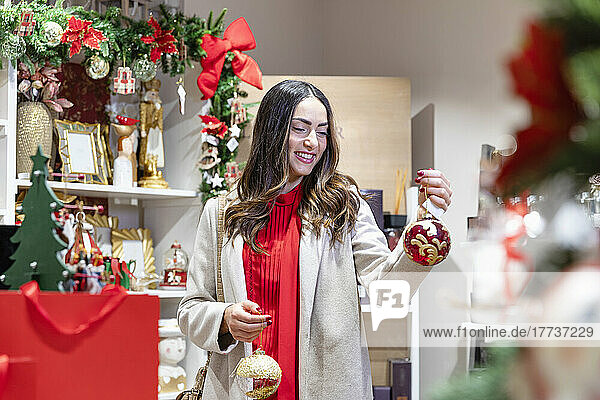 Smiling woman looking at baubles in retail store