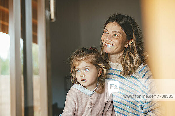 Smiling mother with daughter seen through window