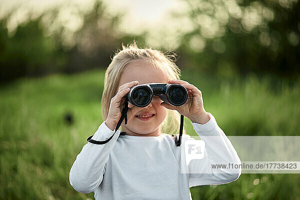 Girl looking through binoculars on weekend