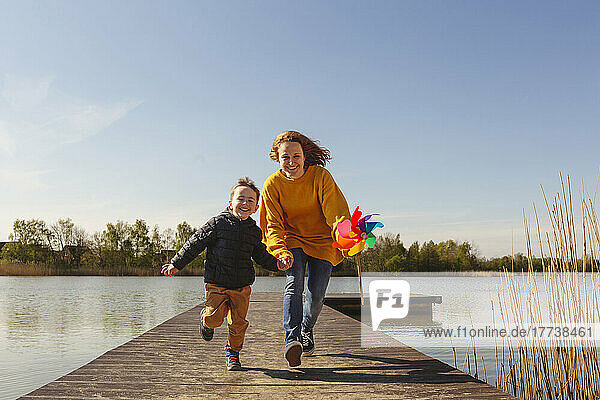 Happy woman with son running on jetty