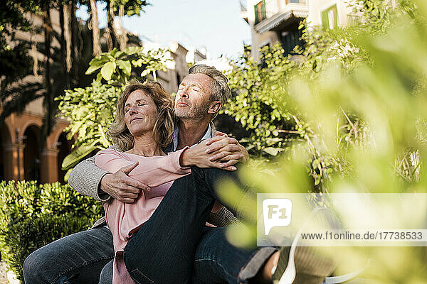 Mature couple with eyes closed in park on vacation
