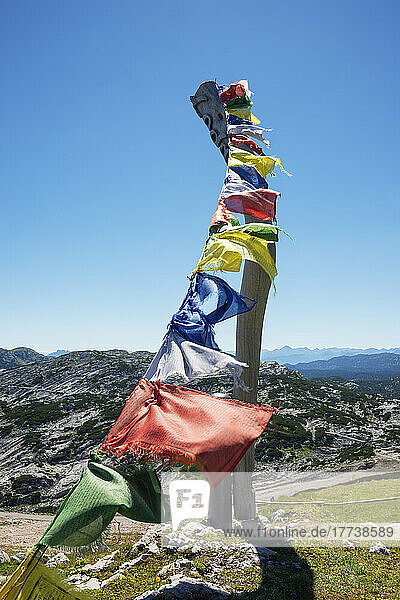 Prayer flags hanging against clear sky with mountains in background