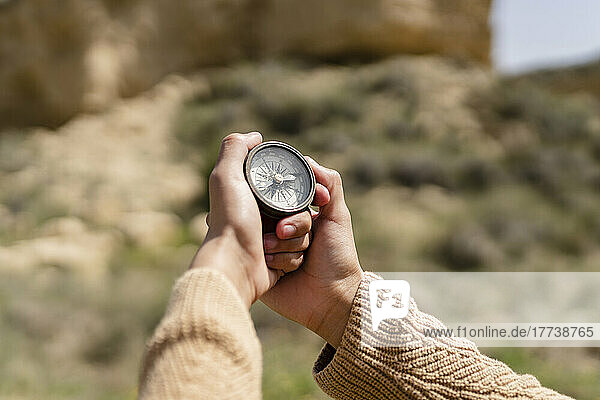 Hände einer Frau  die an einem sonnigen Tag einen Navigationskompass hält