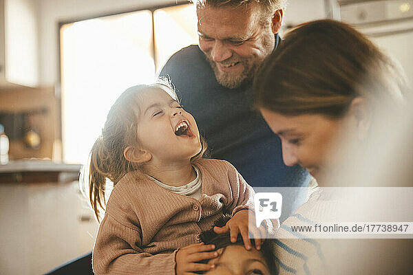 Playful parents with son and daughter at home