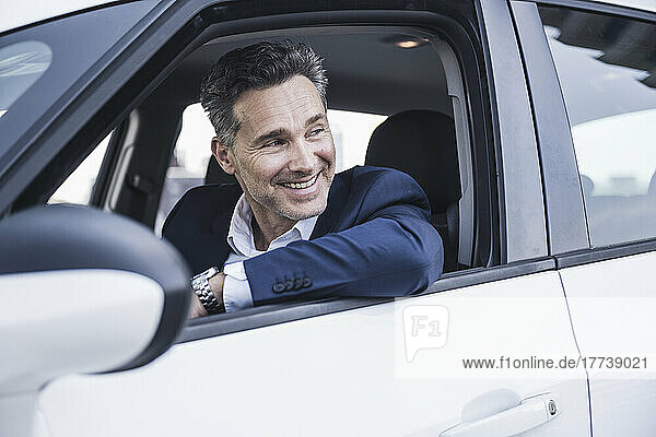 Smiling businessman sitting in car