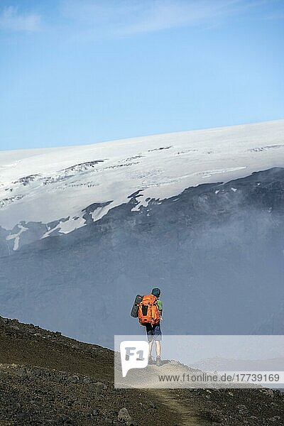 Hikers on trail through volcanic landscape  Myrdalsjökull glacier in the back  Fimmvörðuháls hiking trail  Þórsmörk Nature Reserve  Suðurland  Iceland  Europe