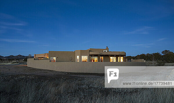 USA  New Mexico  Santa Fe  Pueblo style house in landscape at dusk