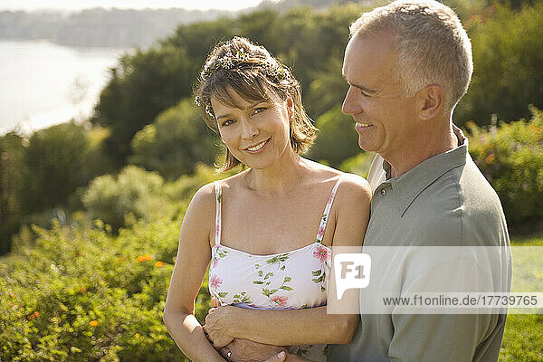 Smiling couple embracing in garden