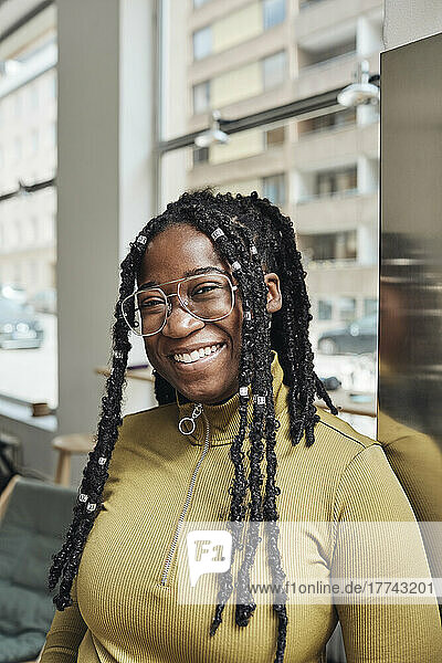 Portrait of happy businesswoman with locs at office