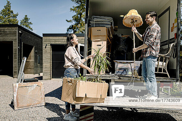Ehepaar entlädt an einem sonnigen Tag Kartons vom Lastwagen