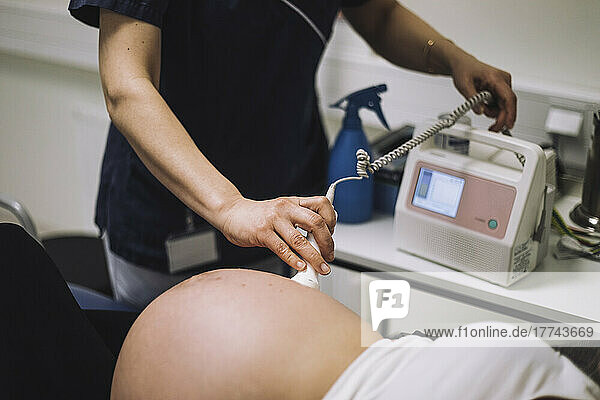 Weiblicher Gesundheitsexperte bei der Ultraschalluntersuchung einer schwangeren Frau in einer medizinischen Klinik