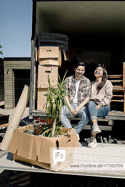 Porträt eines glücklichen Paares im Lieferwagen an einem sonnigen Tag