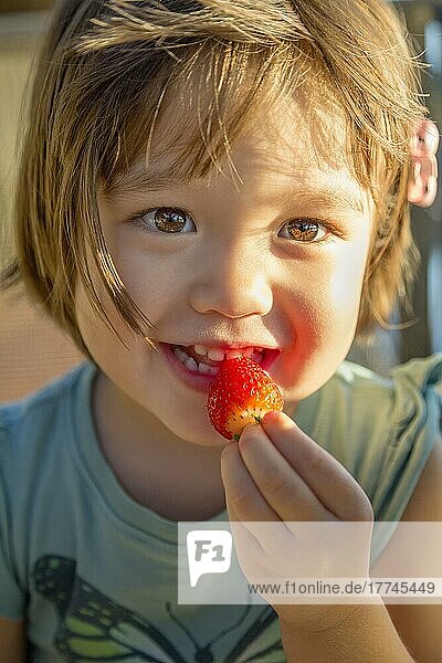 Mädchen im Kleinkindalter ißt eine Erdbeere