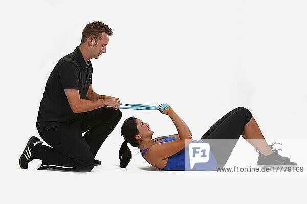 Coach and athlete exercising with Thera-Band  sports exercises